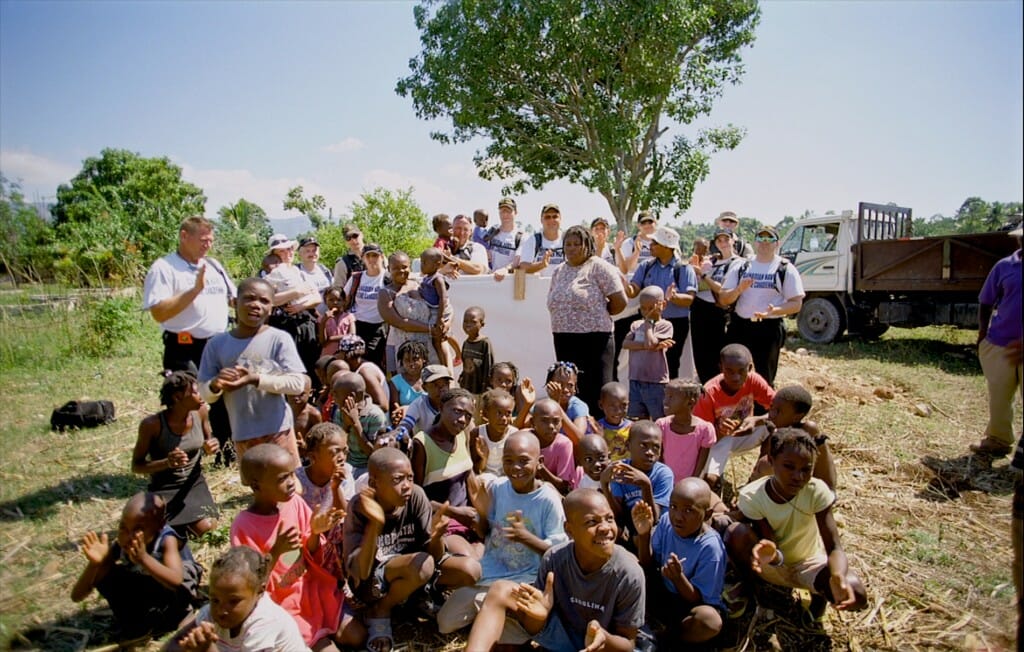 Canadian Navy personnel with Haitian orphans. Image from the giant screen film "Rescue"