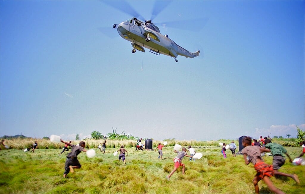 Un hélicoptère Sea King de la marine canadienne effectue une livraison d'eau en Haïti. Image tirée du film sur écran géant 